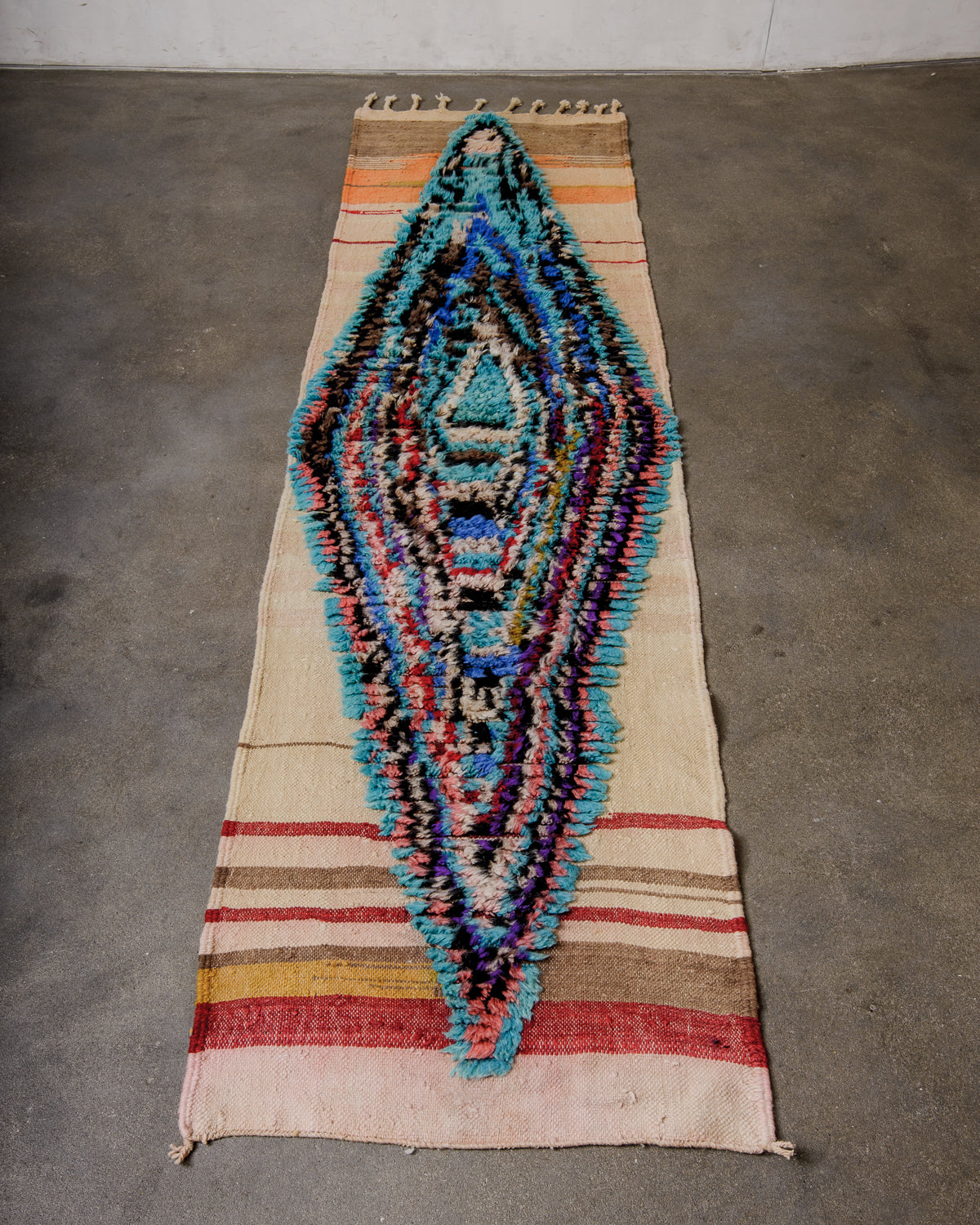 Berberlin vintage runner rug made of flat weave with a fluffy design in the middle, laying flat on concrete floor.